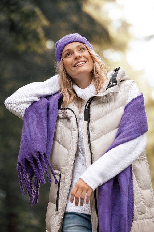 Blonde Frau mit beiger Jacke, lila Mütze und lila Schaal - zum Blogbeitrag: Investorenlösung für LIEBLINGSSTÜCK: Lovely Brands 24! übernimmt Marke, Domain und Warenlager des Modelabels