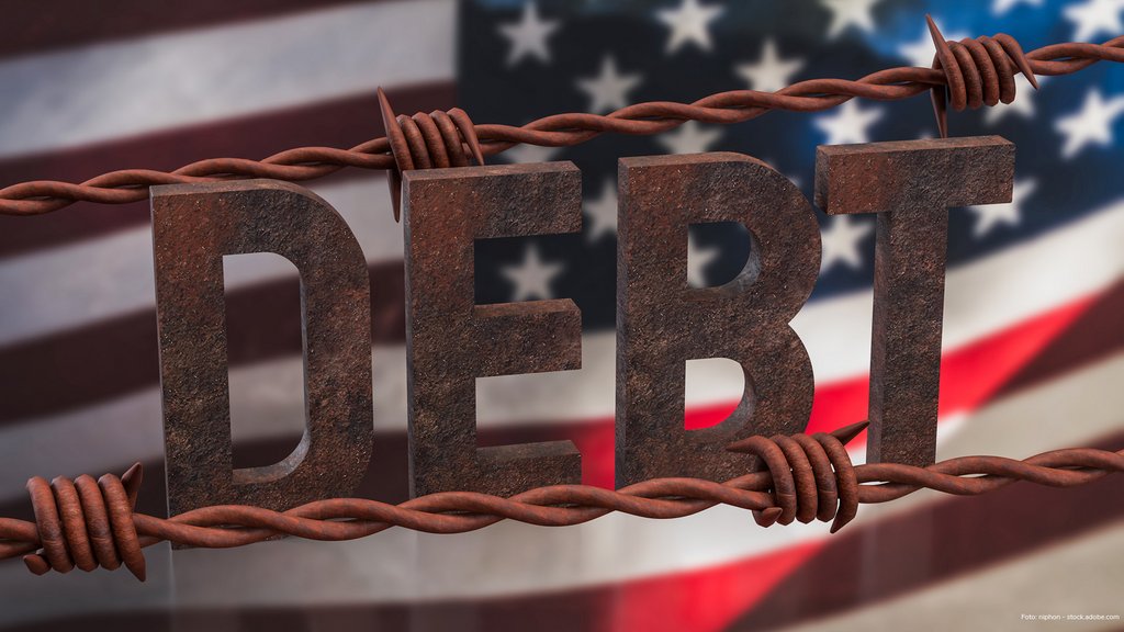 vor der USA-Flagge wird das Wort Debt angezeigt