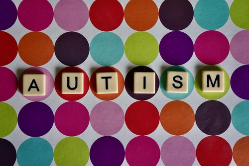 Verschiedene bunte Punkte auf weißem Hintergrund mit Buchstabenwürfel Autism - zum Blogbeitrag: Autismuszentren in Chemnitz und Annaberg-Buchholz bleiben erhalten – SFZ übernimmt