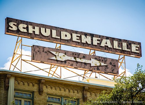 Holzschild mit Schriftzug "Schuldenfalle" - zum Blogbeitrag: Was Insolvenzverschleppung bedeutet und welche Risiken sie für Geschäftsleiter hat