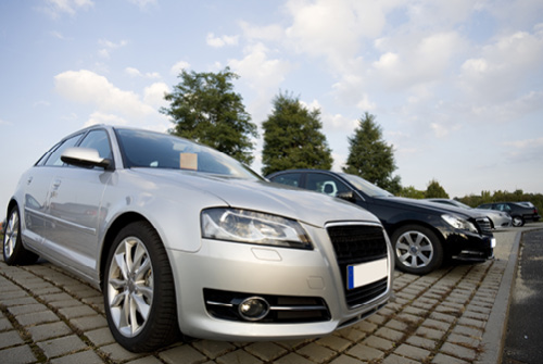 Autos stehen zum Verkauf auf dem gepflasterten Platz eines Autohändlers.